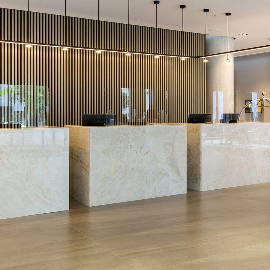 Commercial hotel lobby front desk with custom natural stone countertops fabricated and installed by Stone Top & Glass Studio in New Jersey
